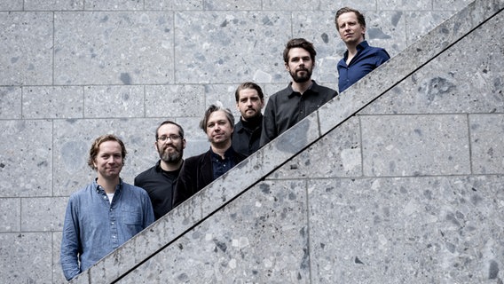 Die sechs Jazzmusiker und Mitglieder des Kölner Jazzkollektivs stehen für ein Pressebild auf einer Treppe. © KLAENG Foto: Nadine Heller-Menzel