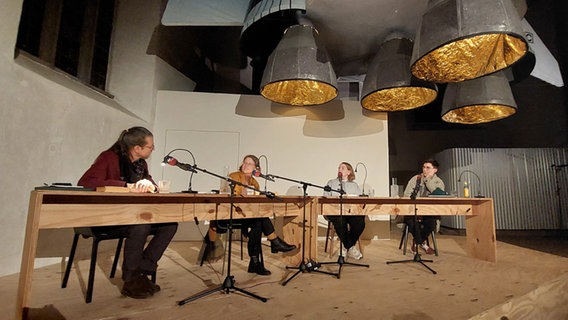 Joachim Dicks, Thea Mengeler, Tatjana von der Beek und Juan Guse sitzen an Tischen auf einer Bühne. © NDR Foto: Alexander Solloch