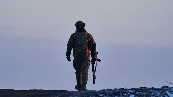 Ein ukrainischer Soldat geht zu seiner Position an der Frontlinie in der Nähe von Bachmut in der Region Donezk. © picture alliance/dpa/AP Foto: Libkos