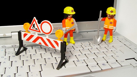 Bauarbeiterfiguren auf einer Tastatur © picture-alliance / OKAPIA KG 
