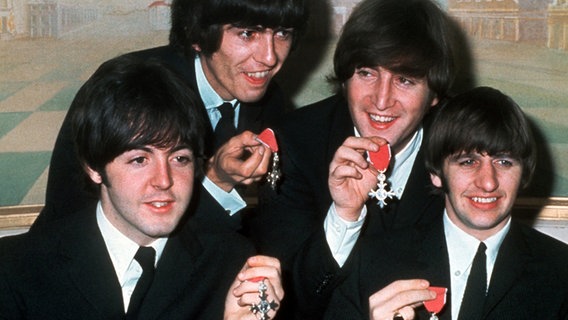 Paul McCartney, George Harrison, John Lennon und Ringo Starr mit den Orden "Member of the Order of the British Empire" (Aufnahme vom 26. Oktober 1965) © dpa 