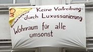 Aus dem Fenster eines Wohnhauses hängt ein Banner - aus Protest gegen das geplante "Bernhard-Nocht-Quartier" in Hamburg © dpa Foto: Maurizio Gambarini