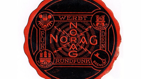 NORAG-Buchstaben als Kreuz mit vier Blitzen in alle Richtungen, rot auf schwarzem Grund. © NDR 