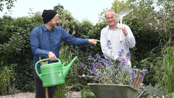 Samir Chawki und Thomas Balster stehen in einem Garten. © NDR Foto: Janis Röhlig