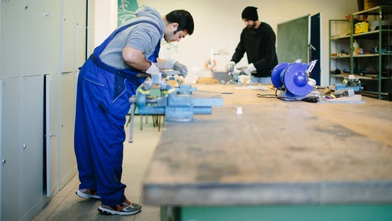 Zwei geflüchtete Menschen arbeiten in einer Werkstatt © picture alliance Foto: Oliver Killig