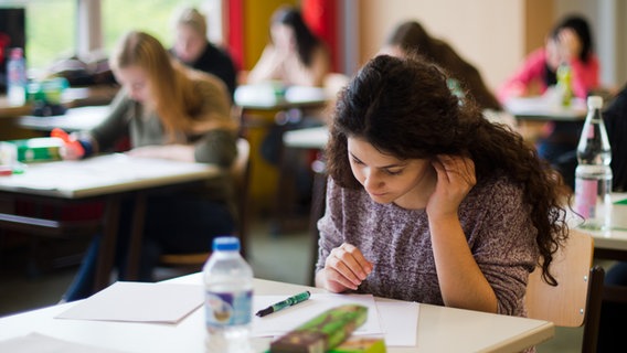 Eine Schülerin sitzt während einer Abiturprüfung in Hamburg am Tisch. © picture alliance / dpa | Julian Stratenschulte Foto: Julian Stratenschulte