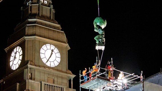 Eine Atlas-Skulptur wird am Abend am Hauptbahnhof mit einem Kran auf das Dach gehoben. © picture alliance/dpa Foto: Daniel Bockwoldt