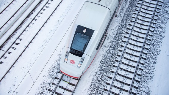 Ein ICE fährt auf einem verschneiten Gleis. © picture alliance/dpa/Daniel Bockwoldt Foto: Daniel Bockwoldt