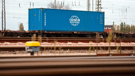 Ein blauer Container steht im Hafen auf einem Frachtwagen. © picture alliance/dpa Foto: Daniel Bockwoldt