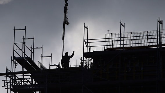 Bauarbeiter stehen auf einer Baustelle in Hamburg. © picture alliance / dpa Foto: Malte Christians