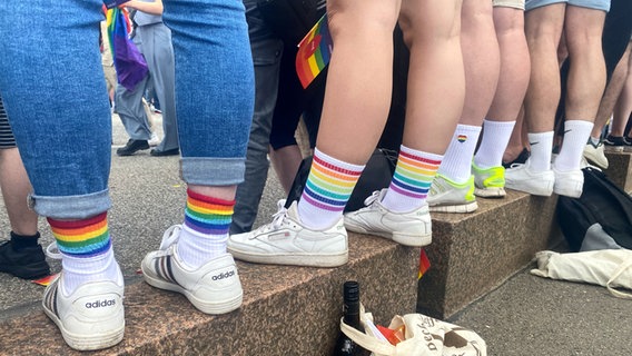 Teilnehmende bei der CSD-Demo in Hamburg tragen Socken in Regenbogenfarben. © Georg Wendt/dpa 