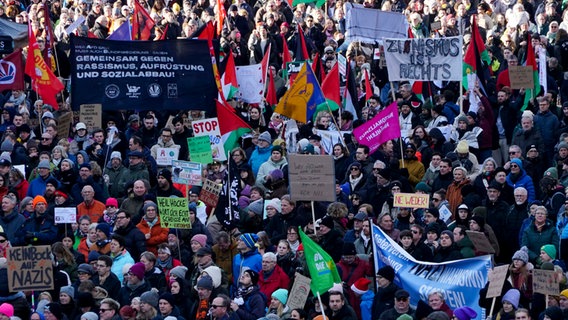 Menschen demonstrieren in Hamburg friedlich mit Fahnen und Bannern. © picture alliance / | - 