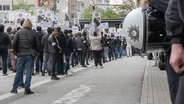 Polizisten stehen neben einer Islamisten-Demo in Hamburg. © IMAGO / Blaulicht News 