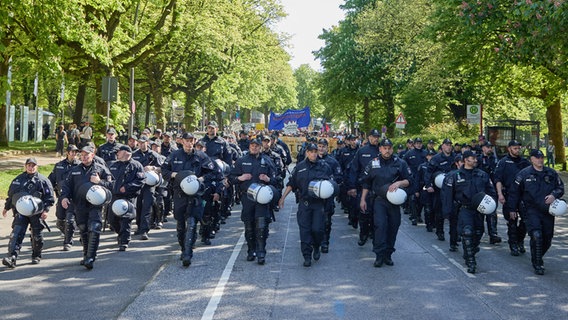 Die Polizei eskortiert die Teilnehmenden einer Demonstration des Bündnis "Wer hat, der gibt" am 01.05.2024 in der Nähe des Hamburger Dammtor-Bahnhofs. © picture alliance/dpa Foto: Georg Wendt