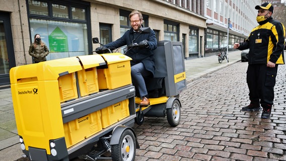 Anjes Tjarks, Senator für Verkehr und Mobilitätswende in Hamburg, testet ein Elektro-Lastenrad der Deutschen Post bei einem Fototermin zur Vorstellung eines Mikrodepots für Warenlogistik in der Innenstadt. © Christian Charisius 