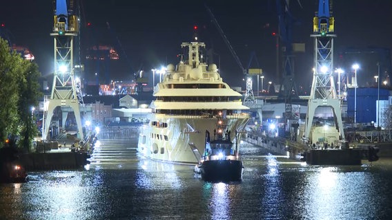 Die Dilbar wird von einem Schlepper aus einem Dock am Hamburger Hafen gezogen. © tv news kontor - Ekberg & Ekberg GbR Foto: Screenshot