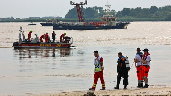 Einsatzkräfte suchen in der Elbe am Falkensteiner Ufer nach einem vermissten Jugendlichen. © picture alliance / dpa Foto: Bodo Marks