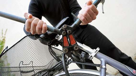 Ein Fahrradschloss wird mit einem Bolzenschneider zerstört. © imago 