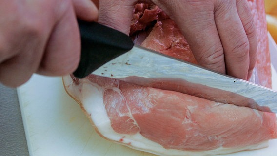 Ein Verkäufer schneidet in Hamburg ein Stück Fleisch ab. © picture alliance / dpa Foto: Markus Scholz