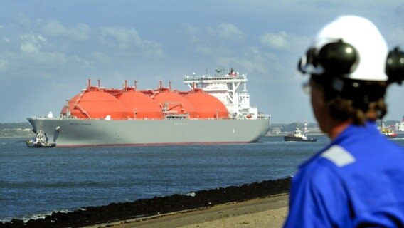 Ein Hafenarbeiter beobachtet einen LNG-Frachter. © dpa Foto: Lex van Lieshout/EPA