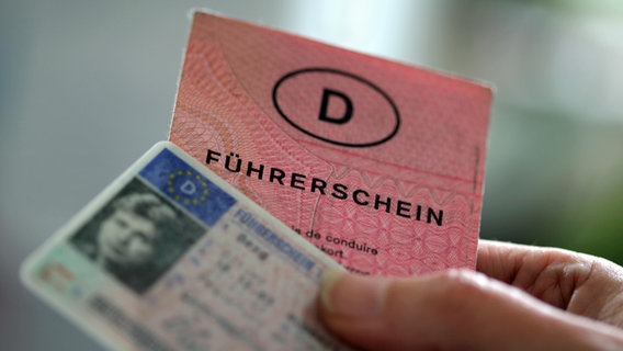 Zwei Führerscheine verschiedener Generationen hält eine Frau in der Hand. © picture alliance/dpa Foto: Oliver Berg