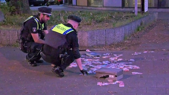 Polizisten sammeln Bargeld ein. Unbekannte hatten einen Geldautomaten der Postbank an der Luruper Hauptstraße gesprengt. © HamburgNews Foto: Christoph Seemann