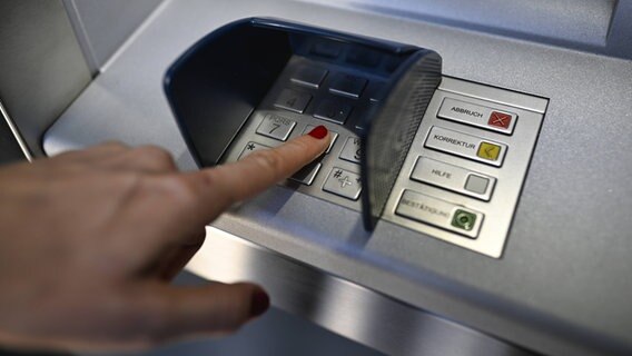 Eine Frau gibt ihre Geheimnummer an einem Geldautomaten ein. © IMAGO / Michael Weber Foto: Michael Weber