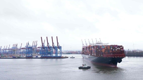 Ein großes Containerschiff wird in Hamburg auf der Elbe an ein Terminal geschleppt. © picture alliance / dpa Foto: Marcus Brandt