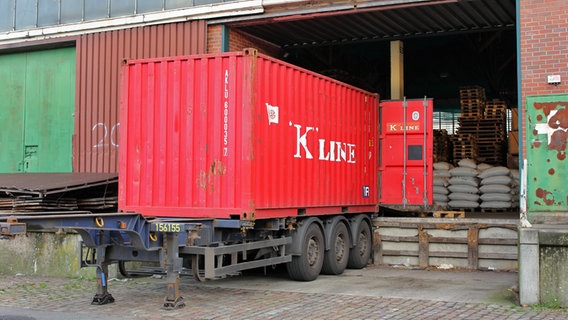 Ein Container-Anhänger steht im historischen Teil des Hamburger Hafens auf dem Kleinen Grasbrook vor einem Schuppen mit Stückgut. © NDR Foto: Daniel Sprenger