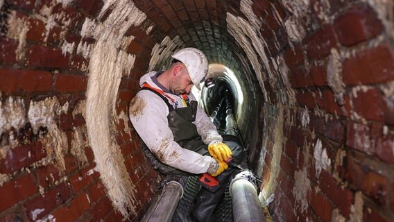 Ein Mitarbeiter von Hamburg Energie arbeitet in einem Tunnel.  Foto: Ulrich Perrey