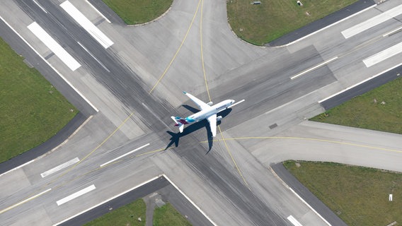 Ein Flugzeug steht auf einer Start- und Landebahn. © picture alliance / imageBROKER Foto: Holger Weitzel