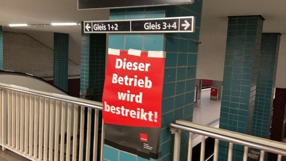 Ein Schild mit der Aufschrift "Dieser Betrieb wird bestreikt" hängt vor den U-Bahngleisen am Berliner Tor. © NDR 