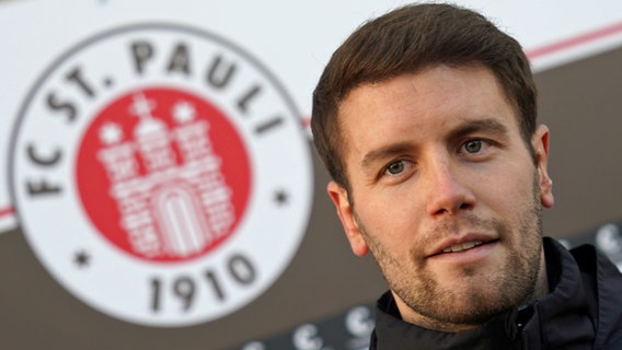 Fabian Hürzeler vor einer Fahne des FC St. Pauli. © picture alliance / dpa Foto: Marcus Brandt