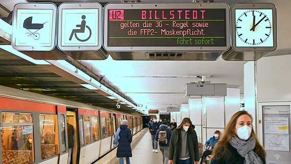 Am Bahnsteig der U-Bahn wird angezeigt, dass eine FFP2-Maskenpflicht in den Bussen und Bahnen des HVV gilt.  