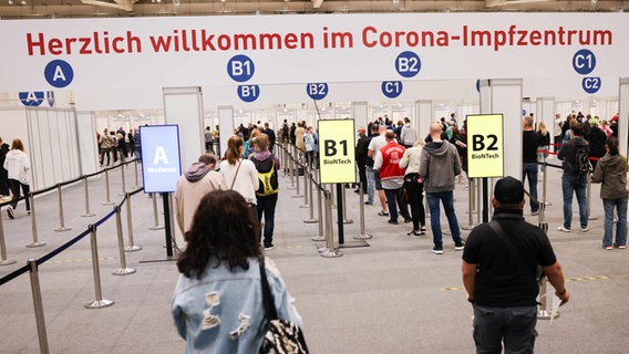 Zahlreiche Menschen warten in einer Schlange in den Hamburger Messehallen auf ihre Corona-Impfung. © picture alliance / dpa Foto: Christian Charisius