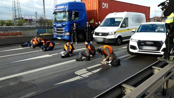Klimaaktivisten kleben sich auf der Fahrbahn der Hamburger Köhlbrnadbrücke fest. Es entseht ein langer Stau. © NDR Foto: NEWS5