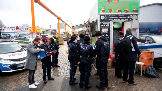 Einsatzkräfte von Polizei, Zoll und Behörden stehen im Hamburger Stadtteil Rothenburgsort in der Billstraße vor einem Imbiss. © picture alliance / dpa Foto: Daniel Bockwoldt