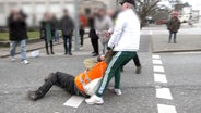 Ein Mann zerrt einen Klimaaktivisten von "Letzte Generation" von der Straße. © TNN 