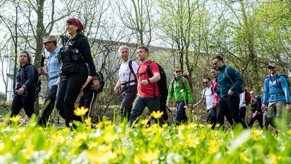 Teilnehmer eines 100 Kilometer langen Megamarsches gehen durch einen Park- © picture alliance/Daniel Bockwoldt/dpa Foto: Daniel Bockwoldt