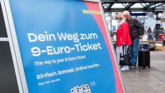 Ein Schild mit der Aufschrift "Dein Weg zum 9-Euro-Ticket" steht im Hamburger Hauptbahnhof. © picture alliance/dpa Foto: Daniel Bockwoldt