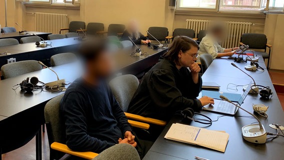 Ein Mann (l.) sitzt in einem Gerichtssaal in Hamburg. Er soll sein Kind entführt und den Flugbetrieb am Hamburger Flughafen stundenlang lahmgelegt haben. © NDR Foto: Elke Spanner
