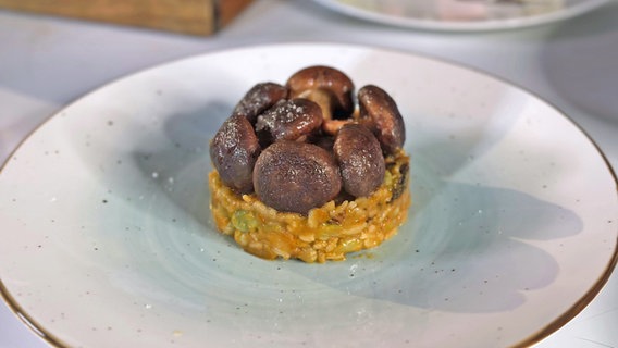 Veganes Risotto mit Shiitake-Pilzen garniert serviert. © NDR Foto: Dave Hensel