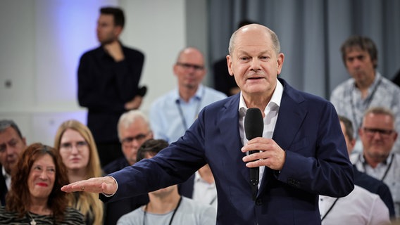 Bundeskanzler Olaf Scholz spricht bei einer Diskussion in Hamburg in ein Mikrofon. © picture alliance / dpa Foto: Christian Charisius