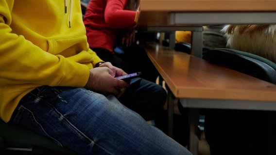 Ein Schüler benutzt ein Smartphone unter dem Tisch. © picture alliance / PantherMedia 