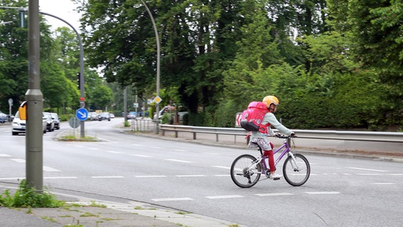 Ein Mädchen fährt in Hamburg mit ihrem Fahrrad zur Schule. © dpa-tmn Foto: Mascha Brichta