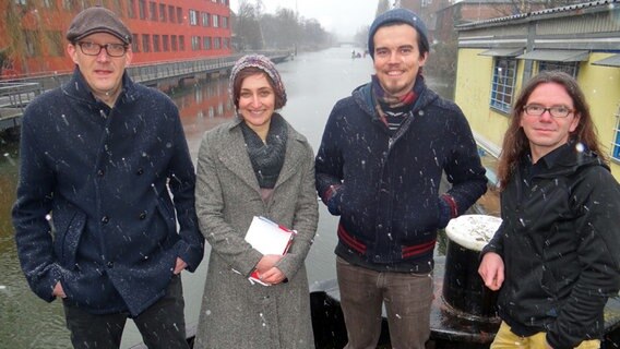 Vier Mitglieder des Vereins Stadtkultur Hafen stehen auf einer Schute in Wilhelmsburg. © NDR Foto: Heiko Block