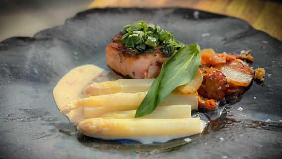 Spargel mit Buttermilch-Zitronensoße, karamellisierten Parmesan-Bratkartoffeln und Lachs von Dave Hänsel auf einem Teller serviert. © NDR Foto: Dave Hänsel