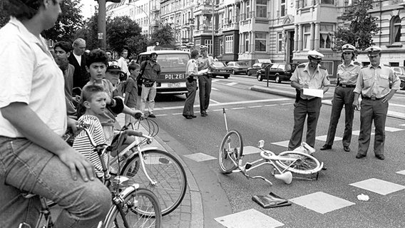 Polizisten stehen vor einem Fahrrad, das auf der Straße liegt. © ullstein bild Foto: Solcher
