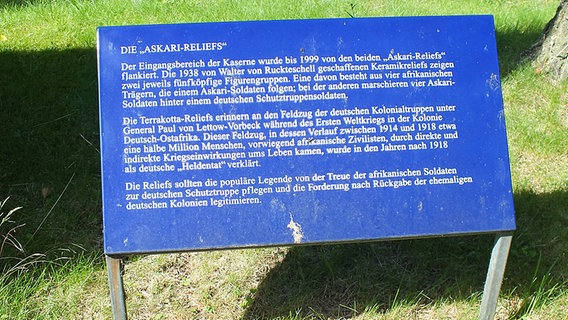 Auf einer Tafel ist die Geschichte der Askari-Reliefs im "Tansania-Park" in Hamburg-Jenfeld zu lesen. © NDR.de Foto: Marc-Oliver Rehrmann