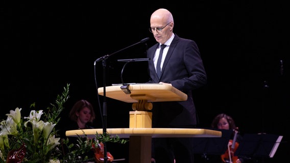 Peter Tschentscher (SPD), Erster Bürgermeister der Freien und Hansestadt Hamburg, redet in der Alsterdorfer Sporthalle bei einer Gedenkveranstaltung der Zeugen Jehovas für die Opfer eine Amoklaufs. © picture alliance/dpa/Jehovas Zeugen in Deutschland, | J.Z. 